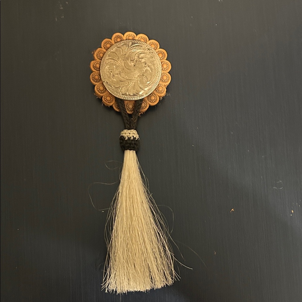 Silver overlaid concho pin with horse hair tassel